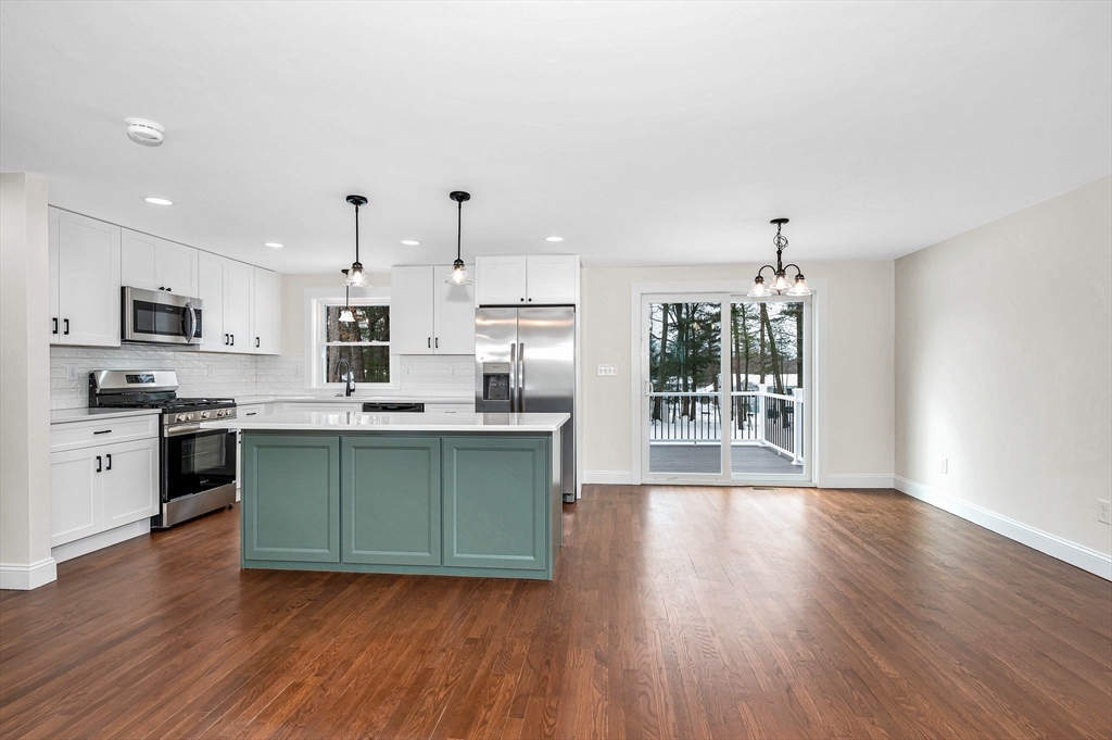 19 Porter Street Billerica, MA 01821 - Photo 4 of 42 a kitchen with stainless steel appliances granite countertop a stove top oven a sink dishwasher and a refrigerator with wooden floor