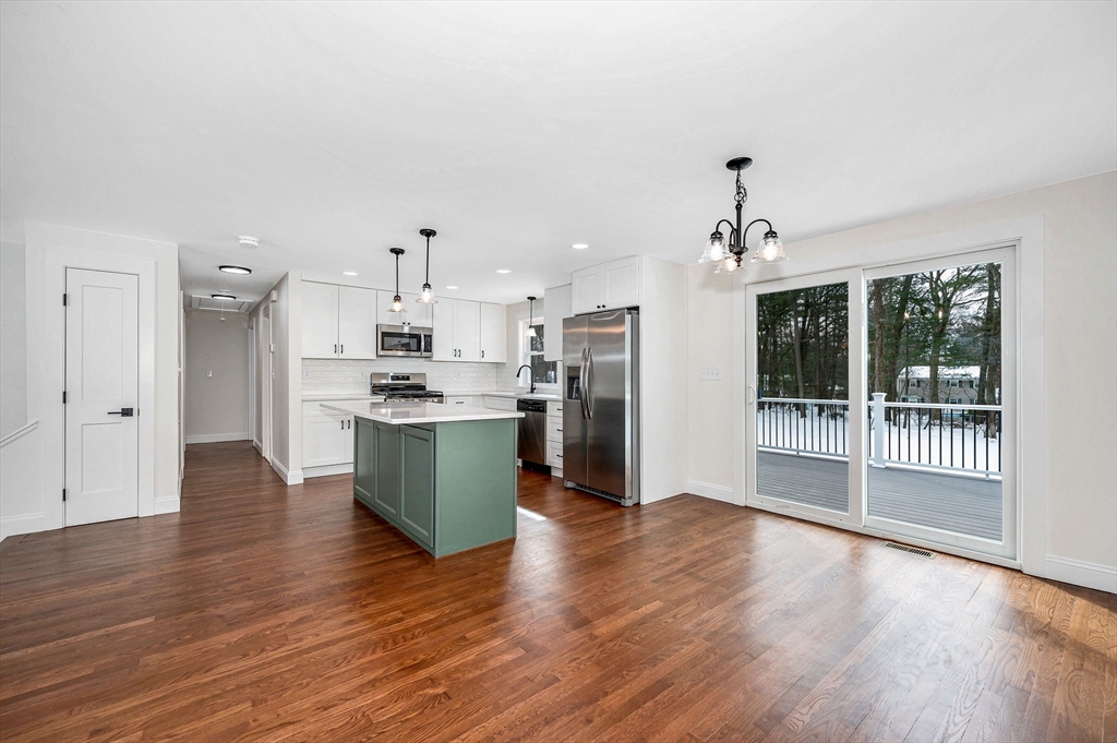 19 Porter Street Billerica, MA 01821 - Photo 6 of 42 a kitchen with stainless steel appliances kitchen island wooden floors and white cabinets
