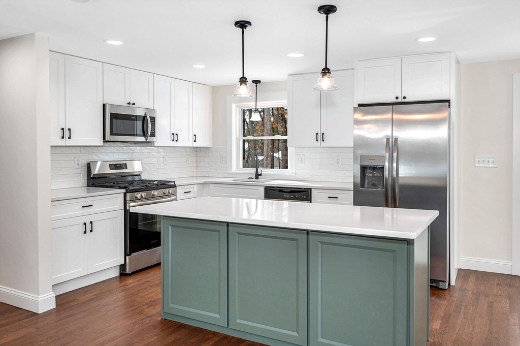 19 Porter Street Billerica, MA 01821 - Photo 8 of 42 a kitchen with kitchen island white cabinets and stainless steel appliances