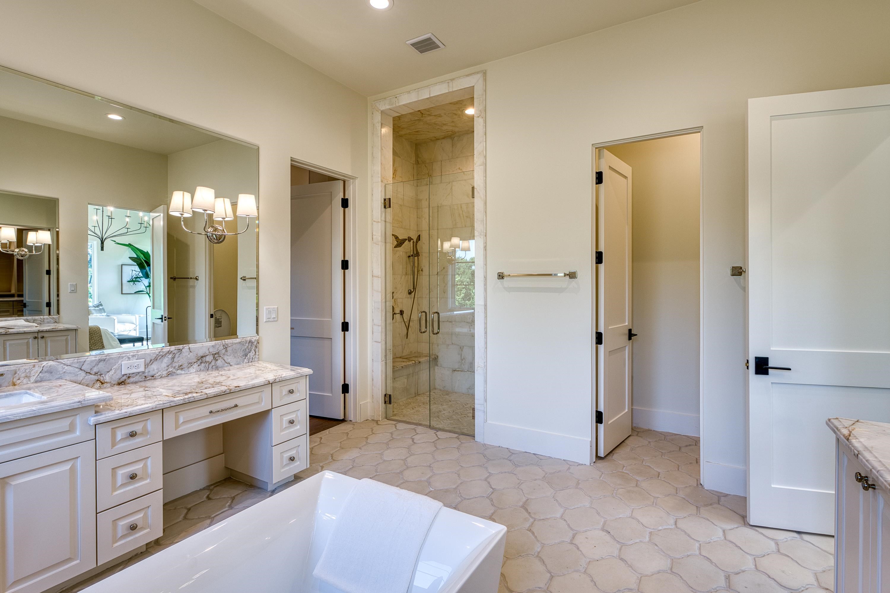 369 La Serena Loop Horseshoe Bay, TX 78657 - Photo 16 of 30 a spacious bathroom with a granite countertop sink mirror and shower
