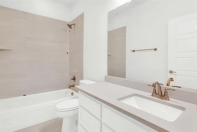 a bathroom with a granite countertop sink mirror vanity and toilet