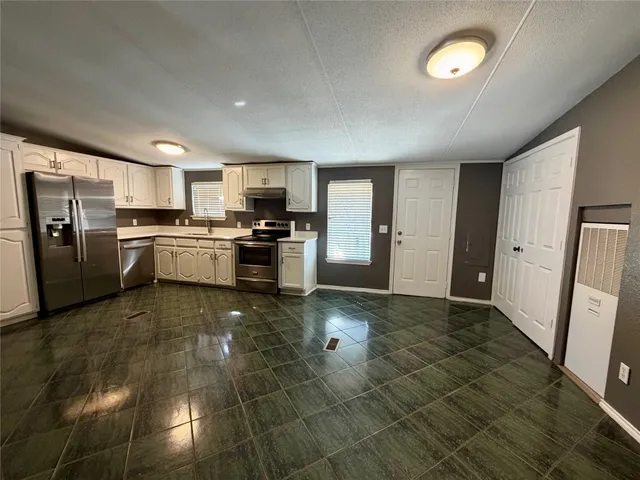 a kitchen with stainless steel appliances granite countertop a refrigerator and a stove top oven