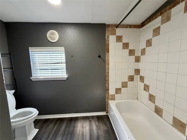 a bathroom with a bathtub and a toilet