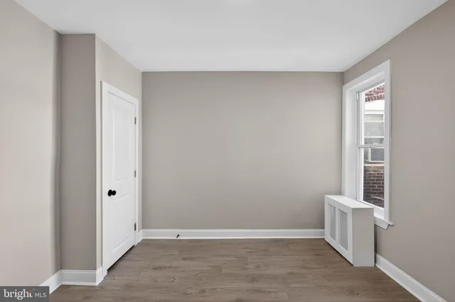 a view of a room with a wooden floor and white walls