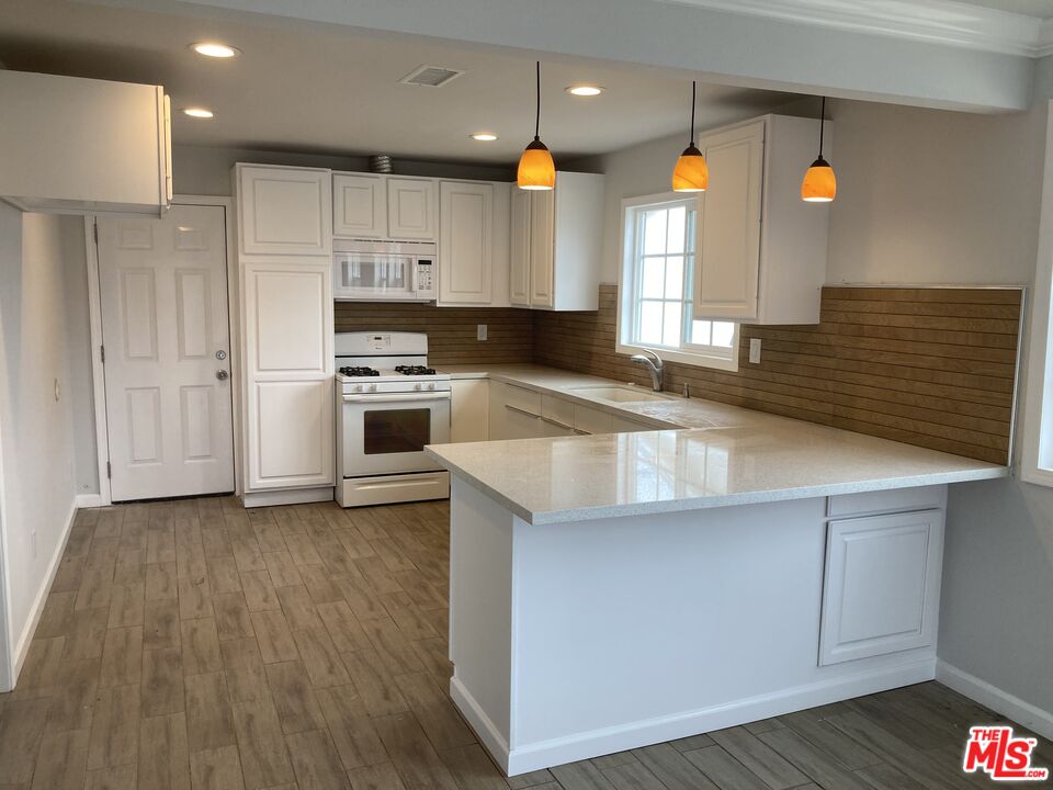a kitchen with a refrigerator a sink and wooden cabinets