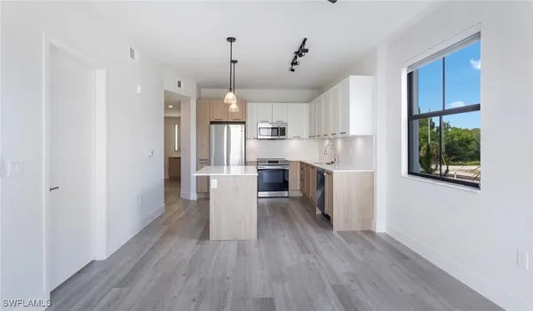 a kitchen with a sink dishwasher a refrigerator and wooden floor