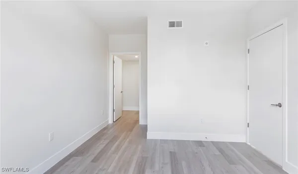 a view of a small space with wooden floor and a window