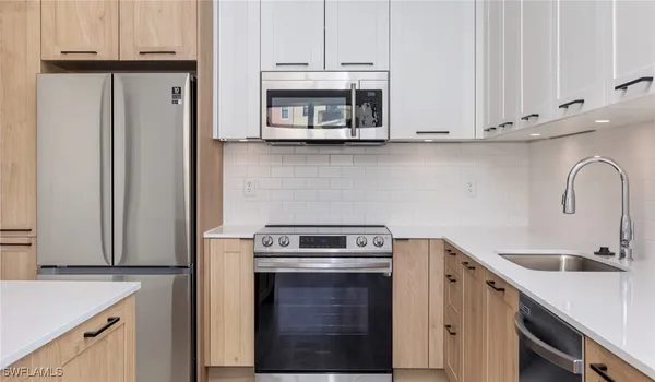 a kitchen with granite countertop white cabinets and stainless steel appliances