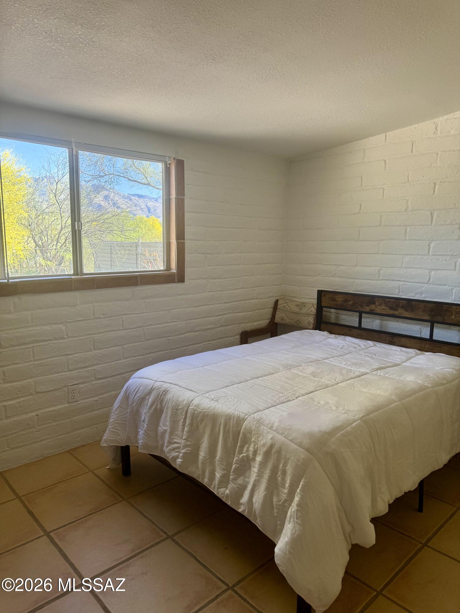 4415 North Swan Road Tucson, AZ 85718 - Photo 19 of 33 a bedroom with a bed and window