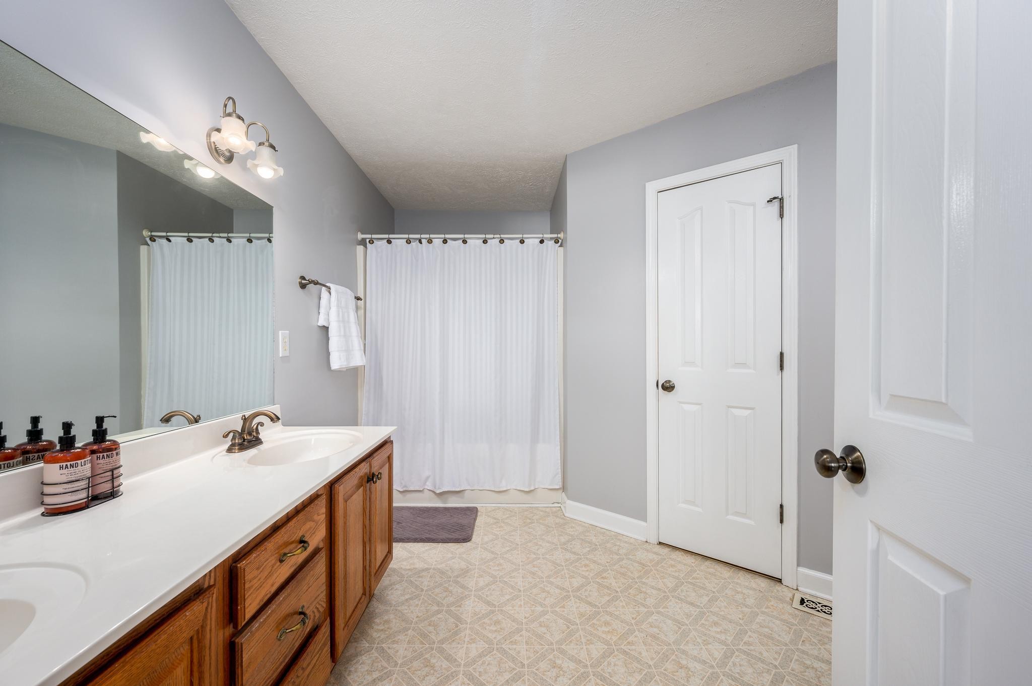 13459 Versailles Road Rockvale, TN 37153 - Photo 14 of 40 a bathroom with a double vanity sink a mirror and shower