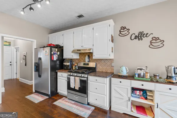 a kitchen with stainless steel appliances a stove a refrigerator and cabinets