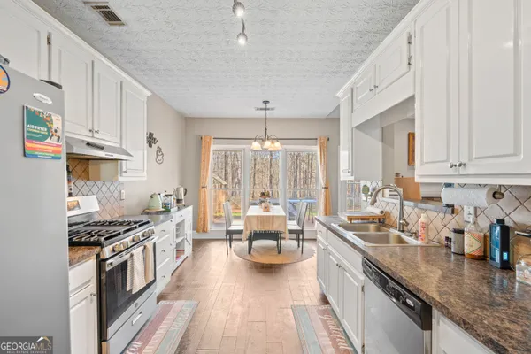 a kitchen with counter top space a sink cabinets and appliances