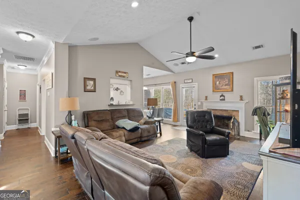 a living room with furniture a fireplace and a chandelier
