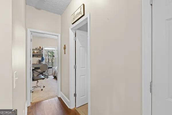 a hallway with wooden floor closet and a bathroom