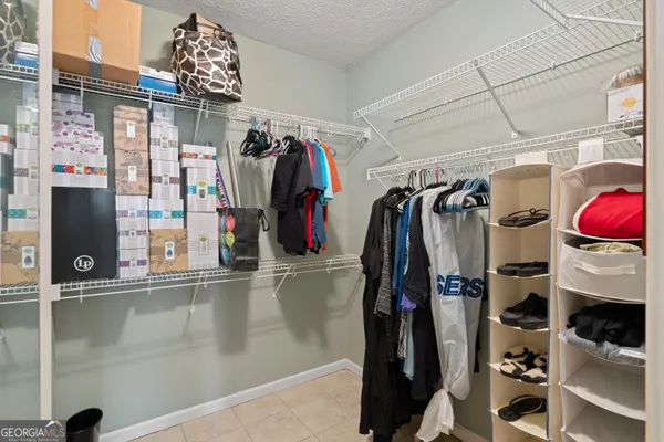a view of walk in closet with clothes and shoes