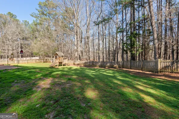 a view of yard with tree and wooden fence
