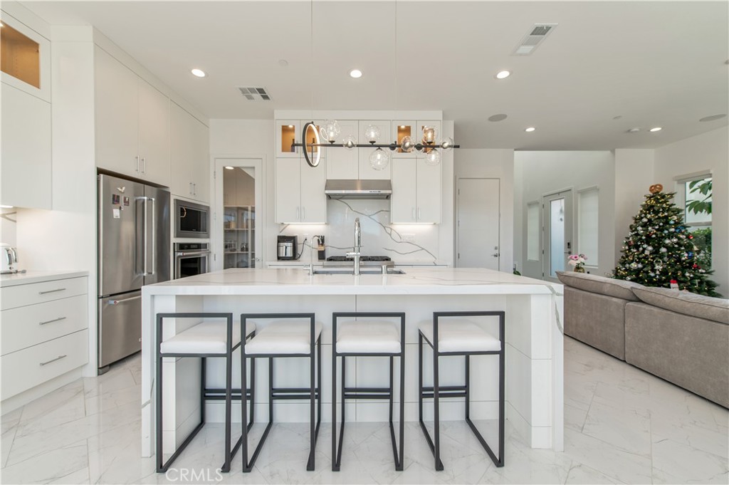 131 Reyes Alley Lake Forest, CA 92630 - Photo 13 of 39 a kitchen with white cabinets and stainless steel appliances