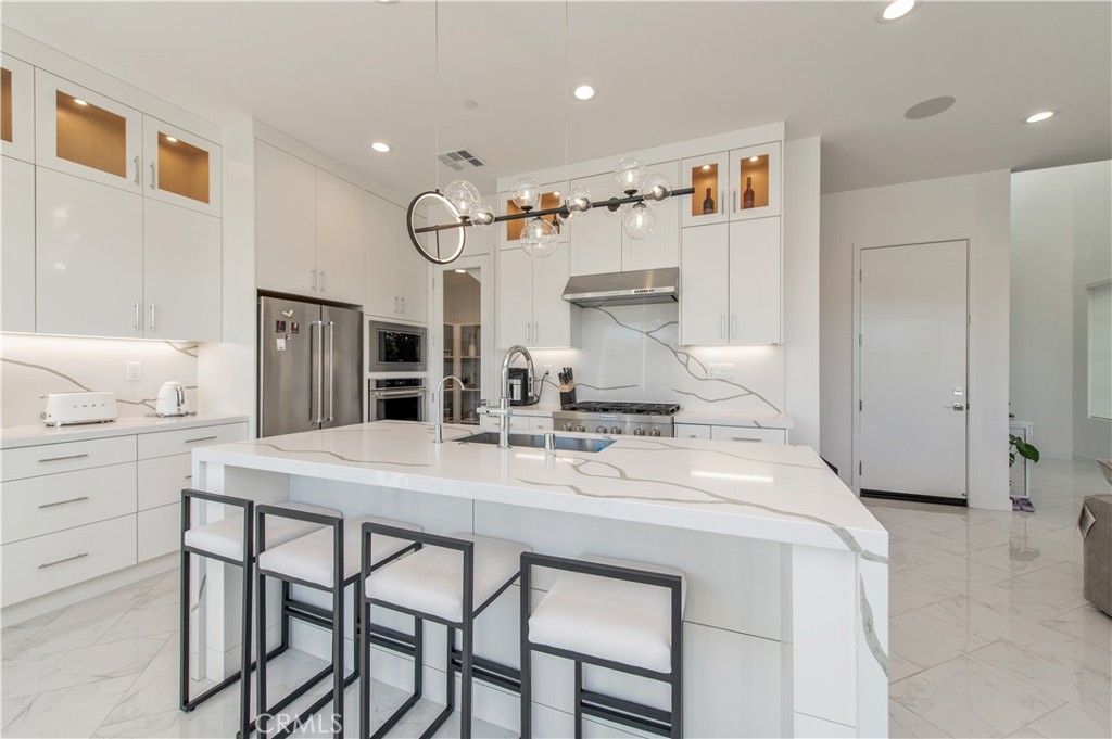 131 Reyes Alley Lake Forest, CA 92630 - Photo 15 of 39 a kitchen with kitchen island a table and chairs
