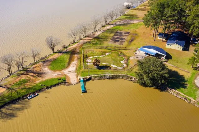 an aerial view of a house with a yard and swimming pool
