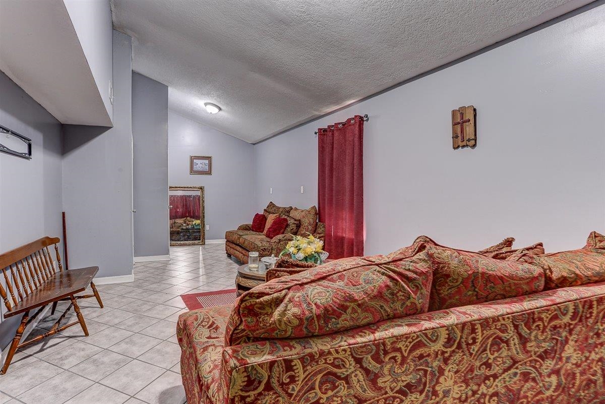 3700 Lakeview Road Memphis, TN 38116 - Photo 19 of 40 Bedroom with light tile patterned floors, a textured ceiling, and lofted ceiling