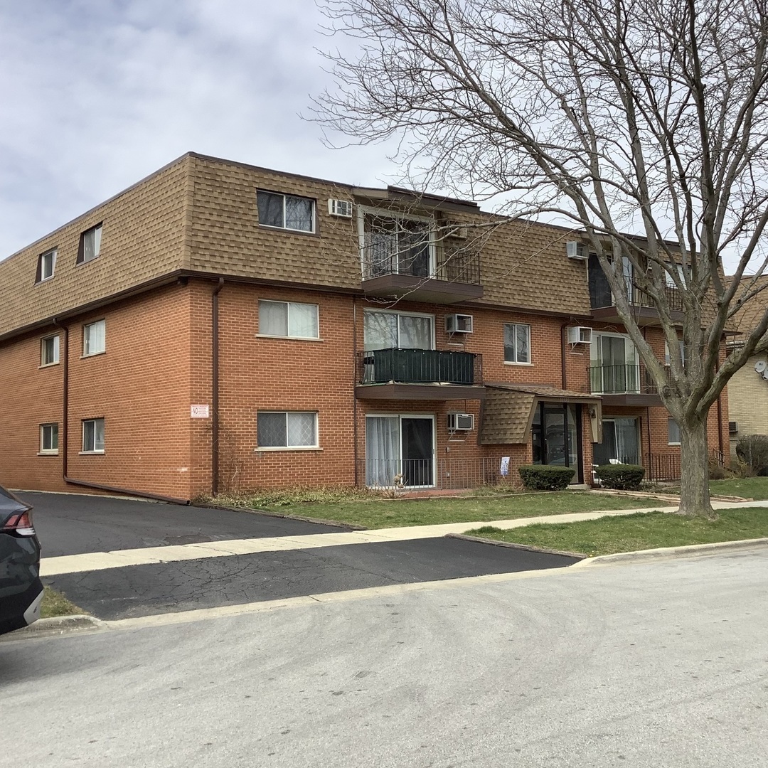 10530 Parkside Avenue, Unit 10 Chicago Ridge, IL 60415 - Photo 1 of 30 a front view of residential houses with yard and trees