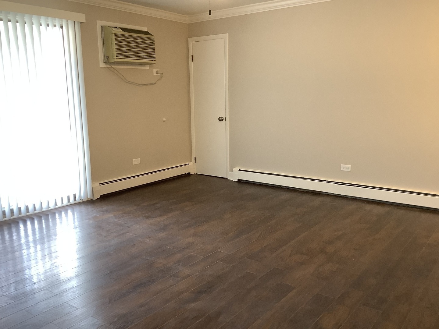 10530 Parkside Avenue, Unit 10 Chicago Ridge, IL 60415 - Photo 20 of 30 an empty room with wooden floor and windows with curtains