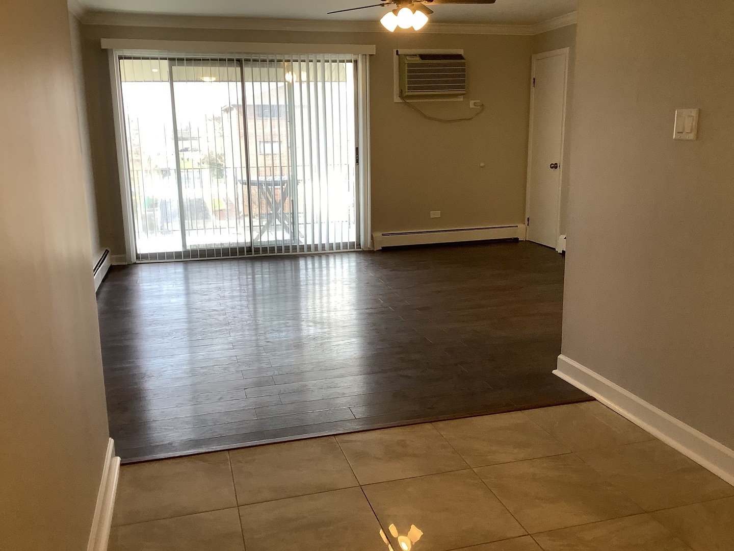 10530 Parkside Avenue, Unit 10 Chicago Ridge, IL 60415 - Photo 21 of 30 an empty room with wooden floor and windows with curtains
