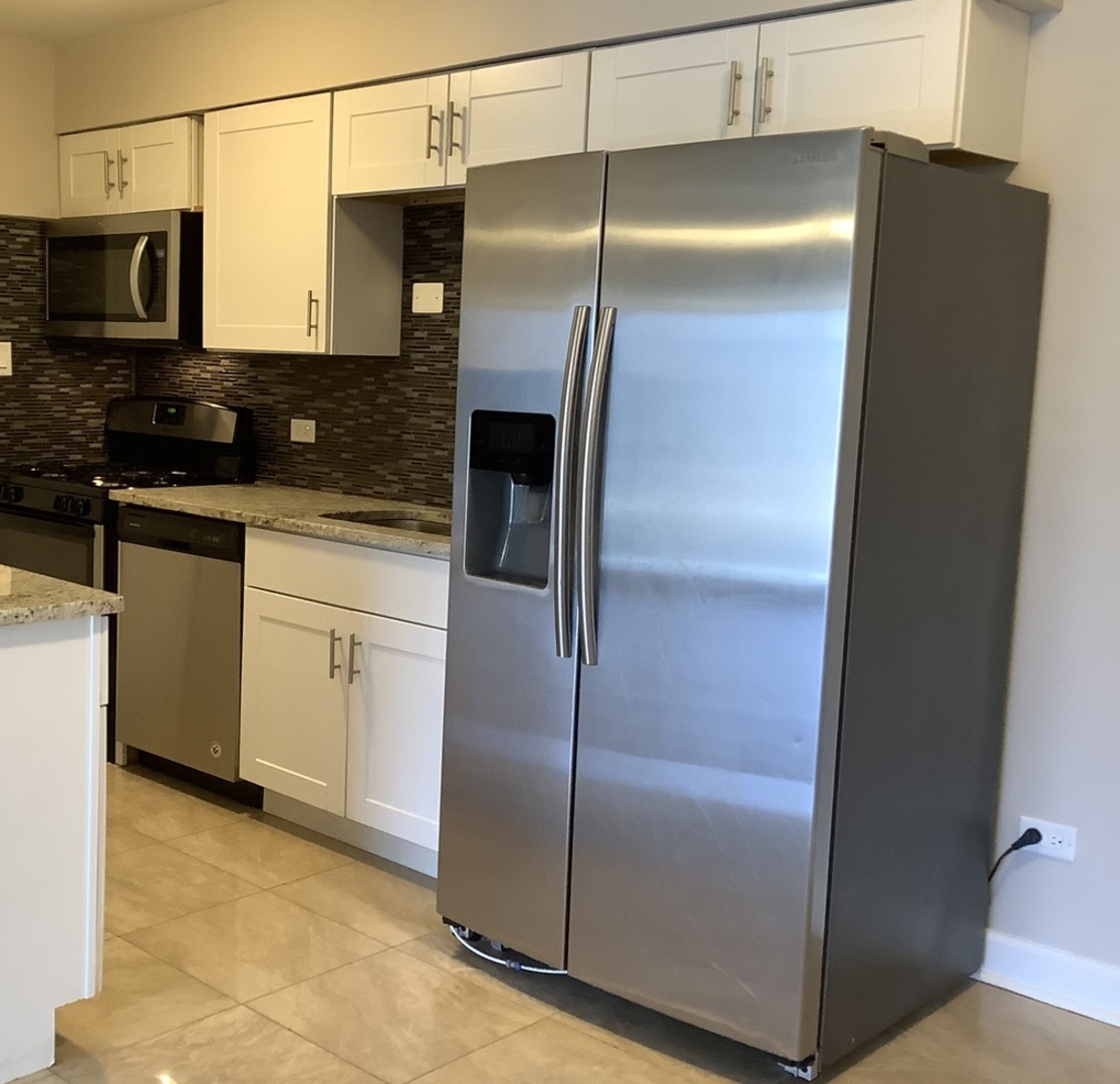 10530 Parkside Avenue, Unit 10 Chicago Ridge, IL 60415 - Photo 4 of 30 a metallic refrigerator freezer sitting in a kitchen