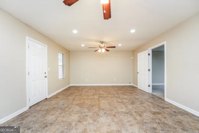 an empty room with fan and windows