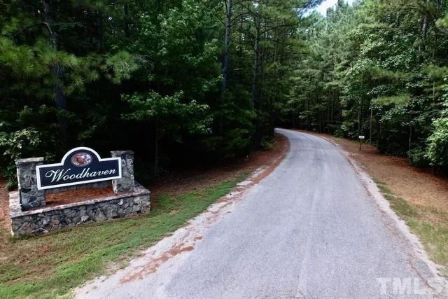 a view of a street with a bench and trees