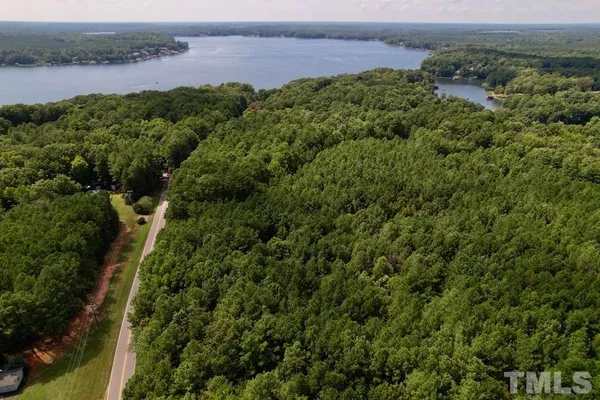 an aerial view of a houses with a yard and lake view