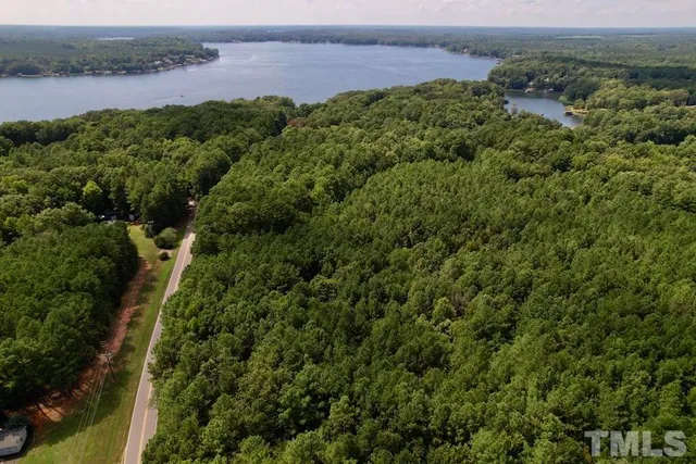 an aerial view of a houses with a yard and lake view
