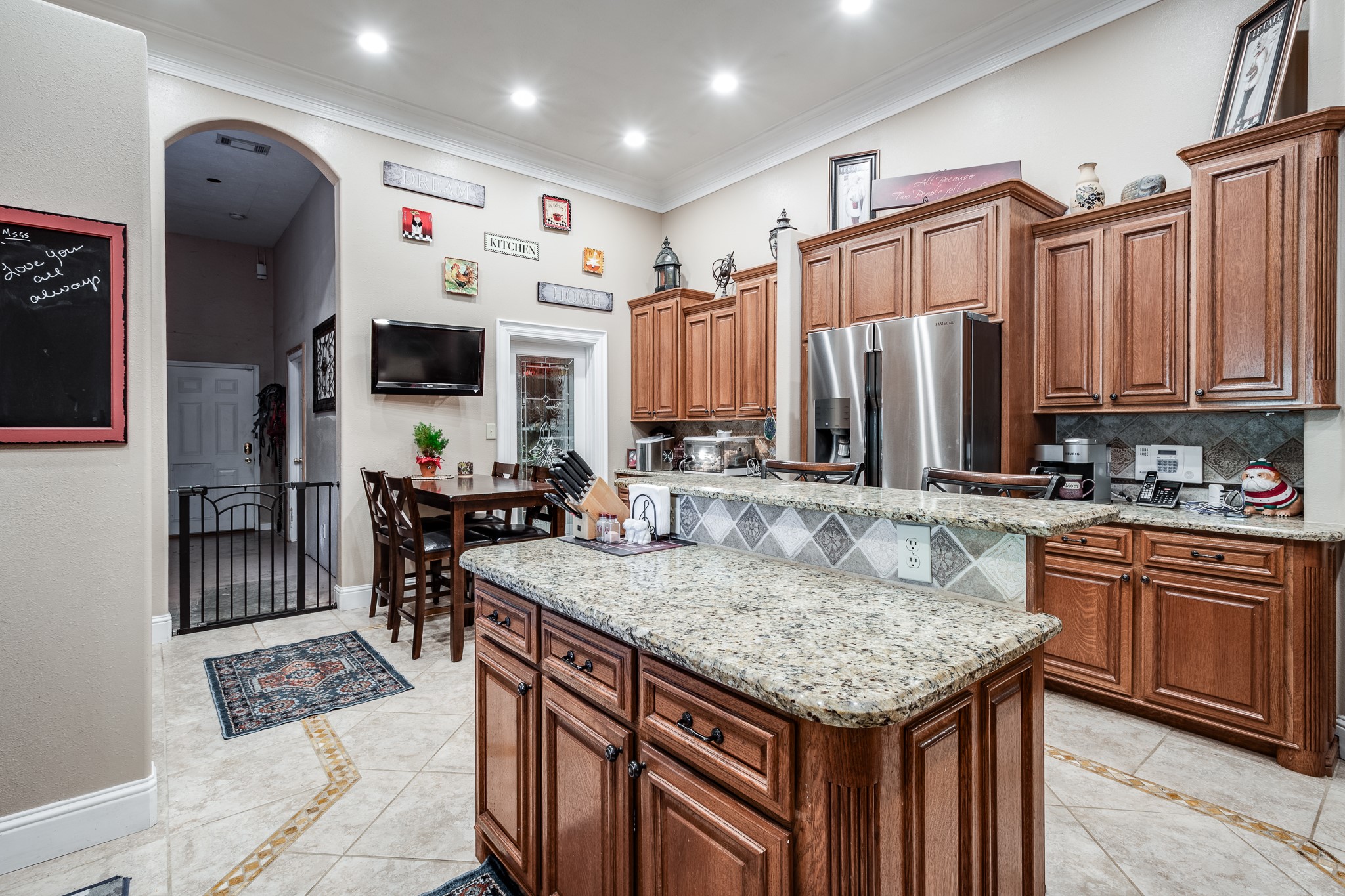 11105 Crockett Martin Road Conroe, TX 77306 - Photo 16 of 35 a kitchen with granite countertop a table chairs stove and cabinets
