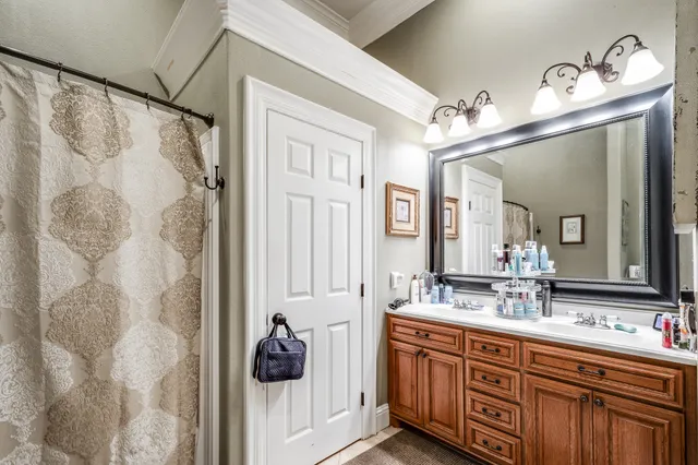 a bathroom with a double vanity sink mirror and shower