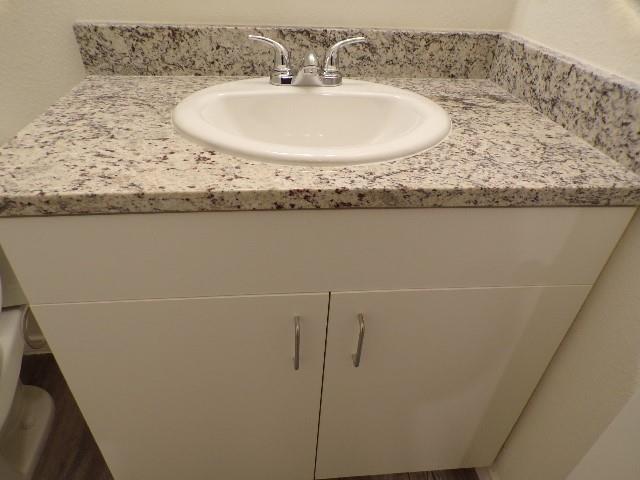 709 South 5th Street, Unit 1 Bonham, TX 75418 - Photo 28 of 32 a bathroom with a granite countertop sink and a mirror
