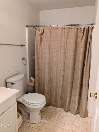 a bathroom with a toilet and a shower curtain