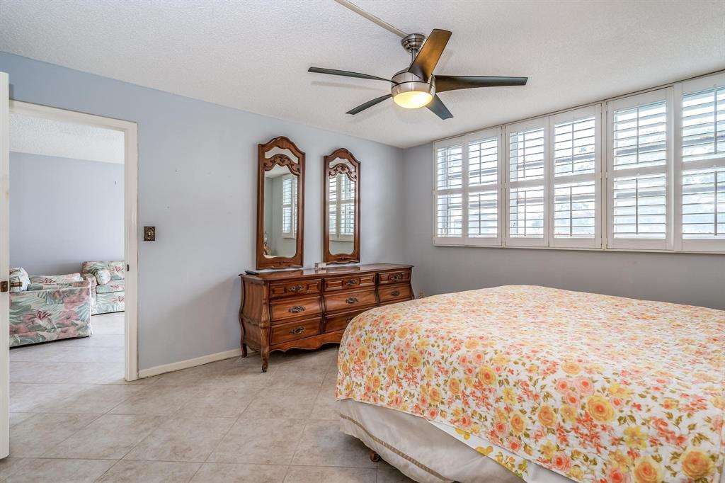 9500 North Hollybrook Lake Drive, Unit 109 Pembroke Pines, FL 33025 - Photo 17 of 57 a bedroom with a bed and a chandelier