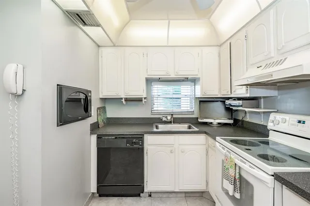 a kitchen with granite countertop a stove sink and cabinets