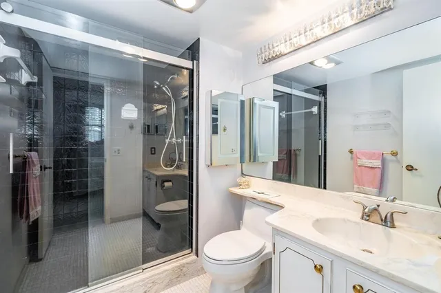 a bathroom with a granite countertop sink toilet and shower