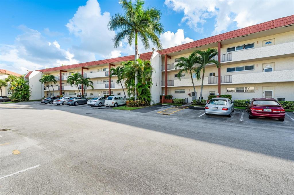 9500 North Hollybrook Lake Drive, Unit 109 Pembroke Pines, FL 33025 - Photo 10 of 57 a city street lined with cars parked in front of a building