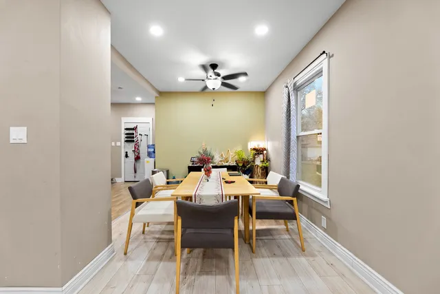 a dining room with a wooden floor and chandelier