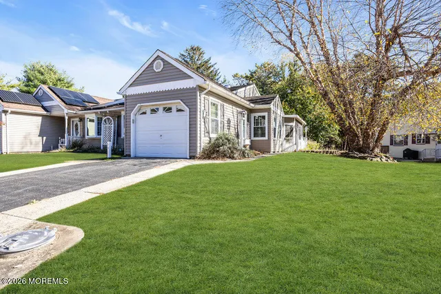 a front view of a house with a garden and trees