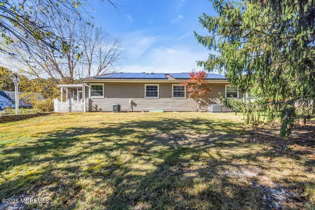 a front view of house with yard and trees around