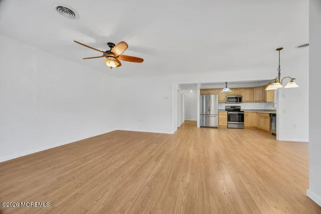 a view of a room with a kitchen and wooden floor