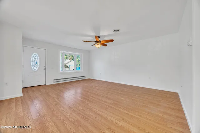 an empty room with windows and cabinet