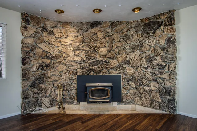 a stone house with a fireplace and wooden floor