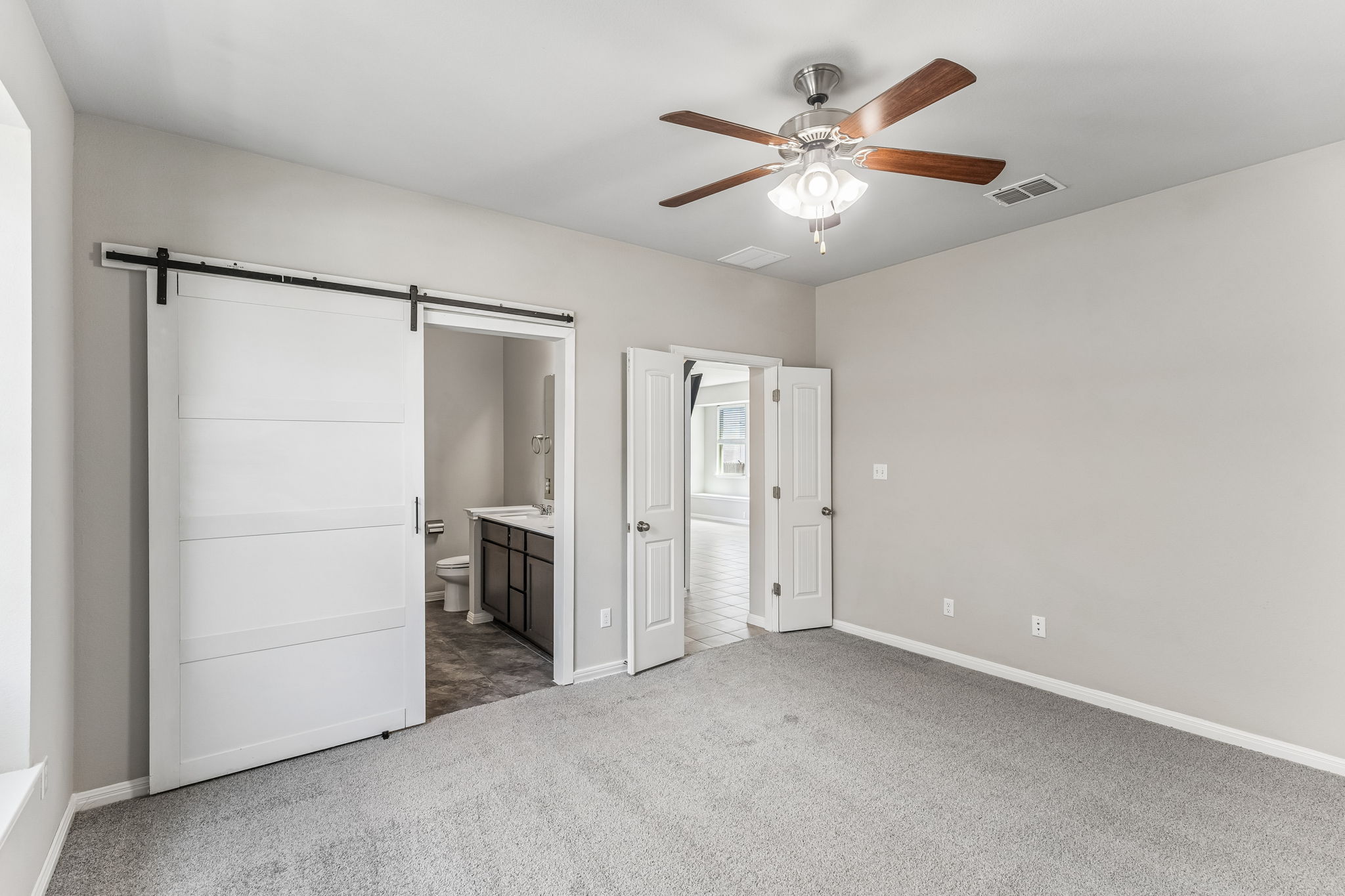 689 Nautical Loop Kyle, TX 78640 - Photo 16 of 34 Relaxing bedroom featuring plush carpet and direct access to a well-appointed private bath.
