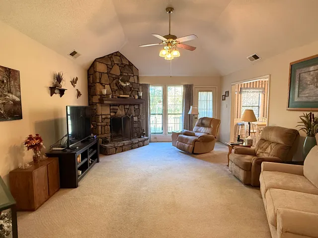 a living room with furniture a fireplace and a chandelier