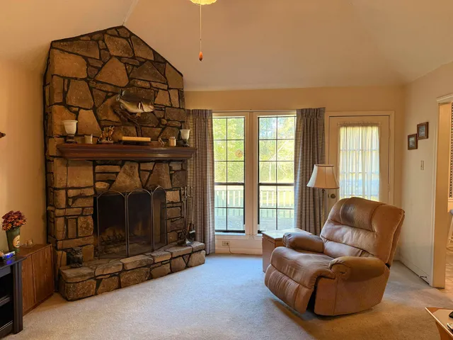 a living room with furniture a flat screen tv and a floor to ceiling window