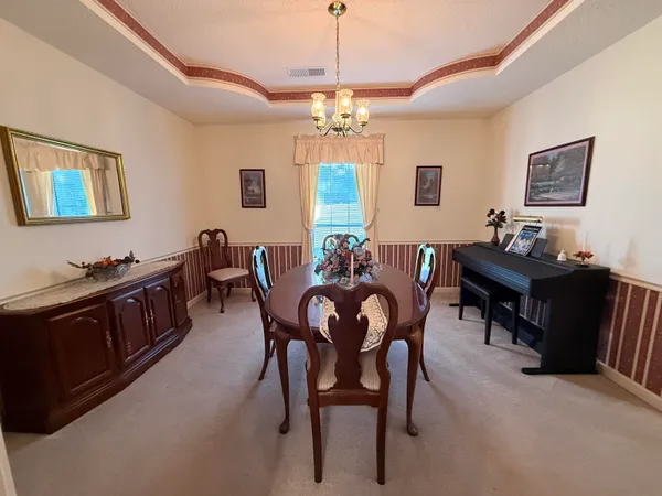 a view of a dining room with furniture and chandelier